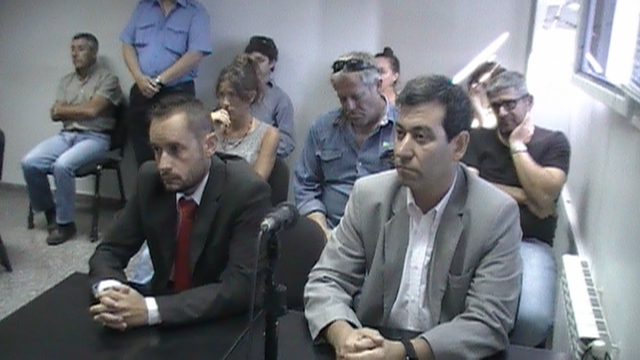 El fiscal y querellante con familiares de víctimas detrás