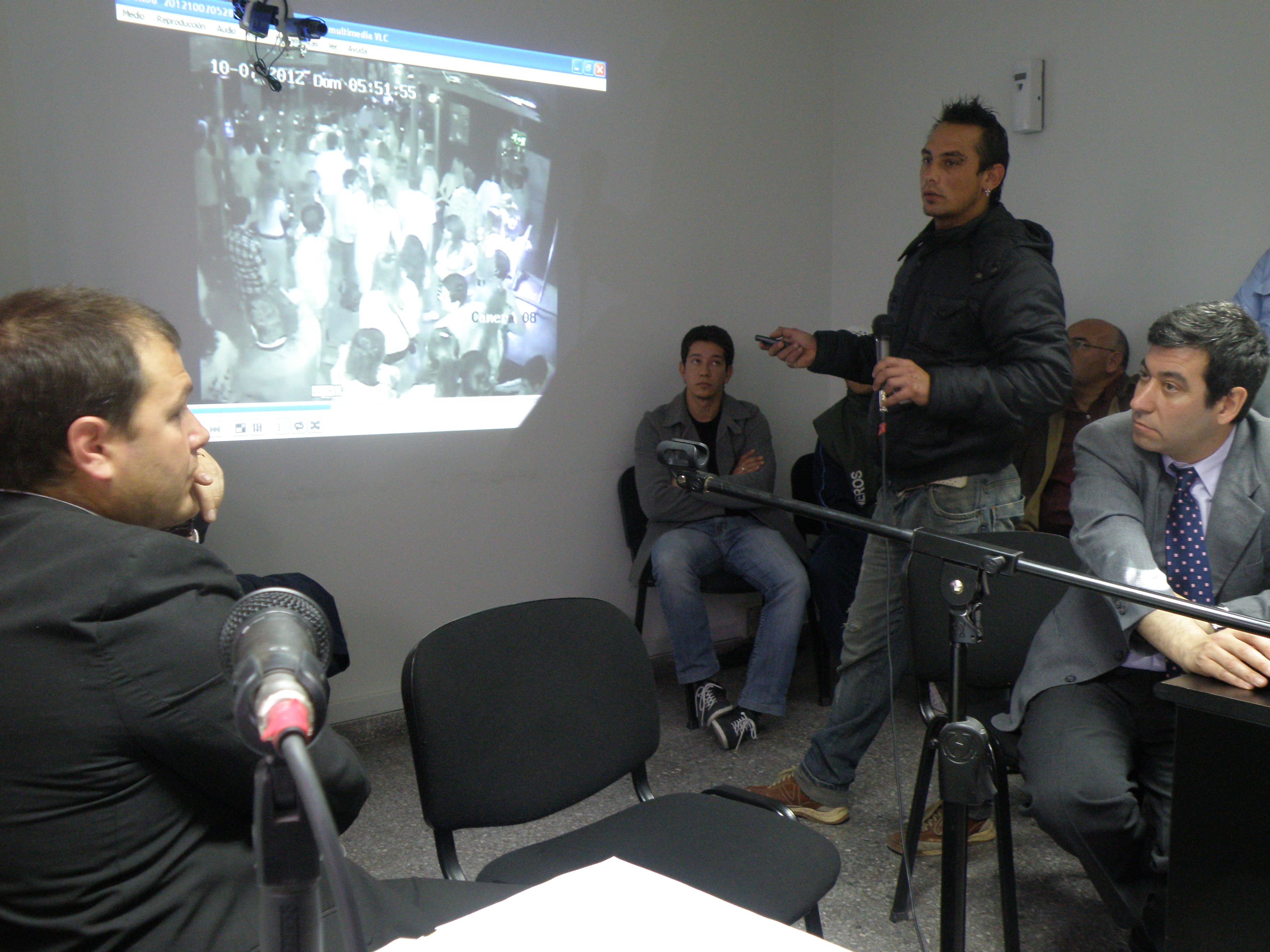 Explicaciones de un testigo con video de fondo