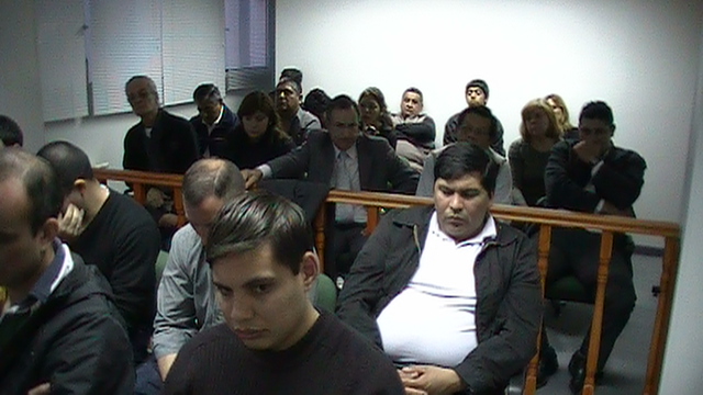 Familiares de acusados en la sala, padres de víctima en el pasillo